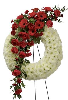 a white wreath with red flowers and greenery on the bottom is placed in front of a white background