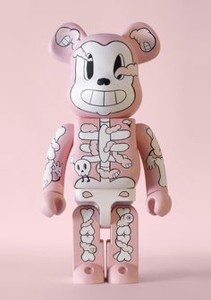 a pink and white skeleton bear toy on a pink background