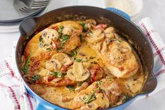 a pan filled with chicken covered in mushrooms