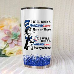 the cat in the hat tumbler has blue sprinkles and is next to flowers