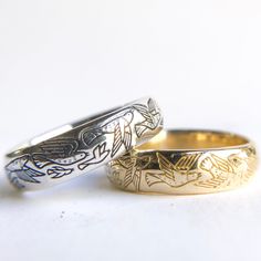 two gold wedding rings sitting next to each other