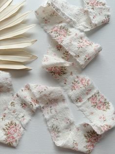 several pieces of cloth with flowers on them and a large white fan next to it