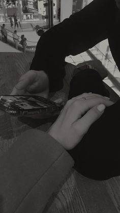 two people sitting at a table with cell phones