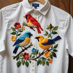 a white shirt with two colorful birds on it