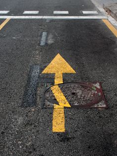 an arrow painted on the road with yellow paint