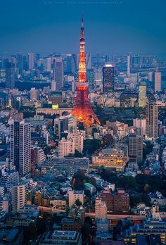 the eiffel tower is lit up in red and yellow at night, as seen from above