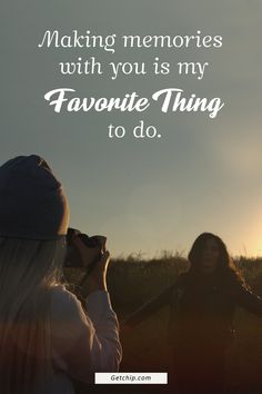 two women standing next to each other holding hands with the sun setting in the background