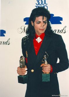 michael jackson holding two awards in his hands