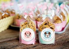 two bags of cookies sitting on top of a wooden table next to other desserts