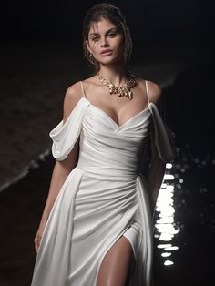 a woman in a white dress is walking on the runway with her leg slited