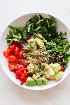 a white bowl filled with lots of different types of salads and veggies