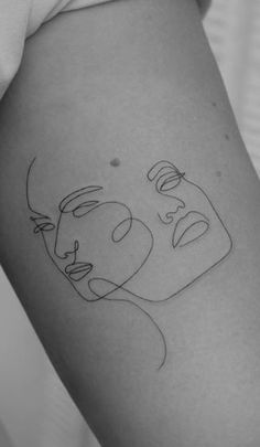 a woman's thigh with a line drawing of two faces on the back of her leg