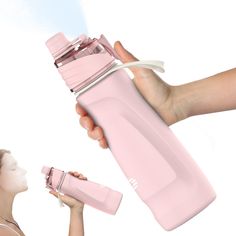 a woman holding a pink water bottle in front of her face and another person's hand