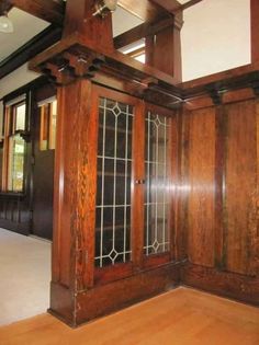 an empty room with wood paneling and glass doors