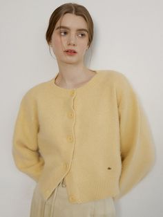 Ivory angora-wool blend cardigan sweater with REORG signature logo in 18k gold. Round neckline, long sleeve, and buttons at front.  - Round neckline- Button closure- Long sleeve Crew Neck Cardigan Knitting Pattern, Butter Yellow Sweater, Collared Cardigan Outfit, Fluffy Cardigan Outfit, German Style Fashion, Wool Cardigan Outfit, Ivory Clothes, Button Up Sweater Outfit, Yellow Cardigan Outfits