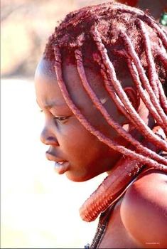 a close up of a child with dreadlocks on her head and hair in the wind