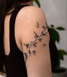 a woman with a tattoo on her arm is looking at the back of her shoulder