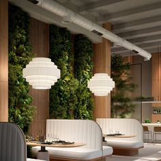 the restaurant is decorated with greenery and white furniture