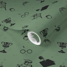 a green wallpaper with black and white harry potter symbols on it, as well as glasses