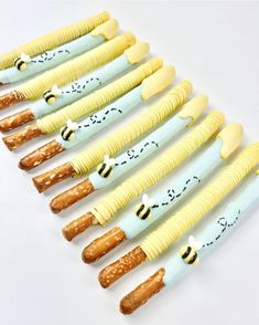 eight bees are lined up in the shape of toothbrushes with yellow and blue tips