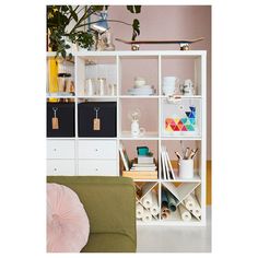 a living room filled with furniture and lots of storage space next to a wall mounted shelf