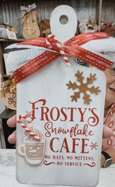 frosty's snowflake cafe sign in front of a woman holding it