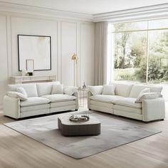 a living room filled with white furniture next to a large window on top of a hard wood floor