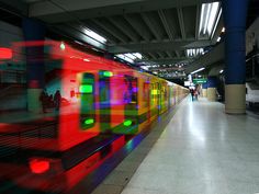 a red train traveling down tracks next to a loading platform