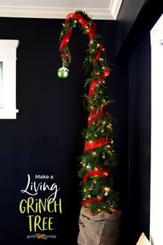 a christmas tree with red ribbon hanging from it's top and the words make a living grin tree