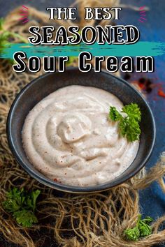 the best seasoned sour cream recipe in a bowl with parsley and cilantro