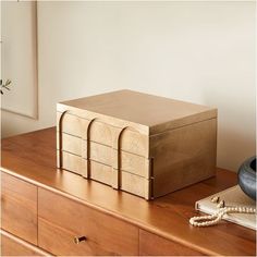 a wooden box sitting on top of a dresser