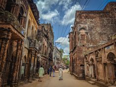 people are walking down the street in an old city