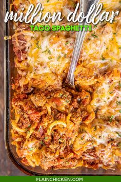 a casserole dish with meat and cheese in it on a wooden table next to a fork