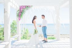 a man and woman standing under a white gazebo