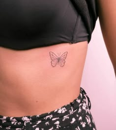 a woman's stomach with a small butterfly tattoo on the side of her belly