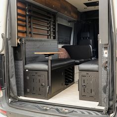 the back end of a van with its doors open and seats folded down in front