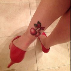 a woman's red high heeled shoes with a rose tattoo on her ankle