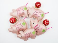 four pink pig ornaments with numbers on them