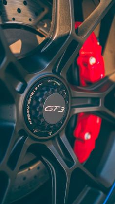 the wheel and tire of a sports car with red brake pads on it's rim