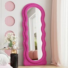 a bedroom with a large pink mirror on the wall