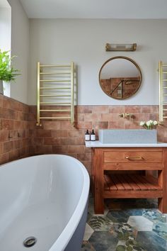 a bathroom with a sink, mirror and bathtub next to a plant on the counter