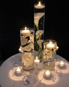 candles and flowers in glass vases on a table