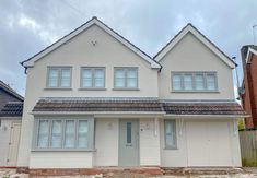 two story white house with three windows on the front and one door open to let in light