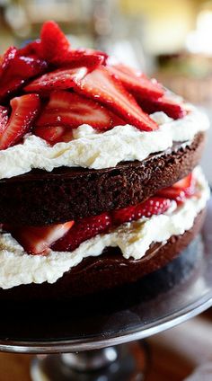 a chocolate cake topped with strawberries and whipped cream