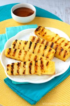 grilled pineapples on a plate with dipping sauce