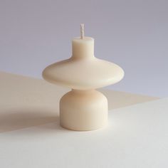 a white candle sitting on top of a table