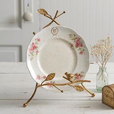 a white plate sitting on top of a table next to a vase filled with flowers