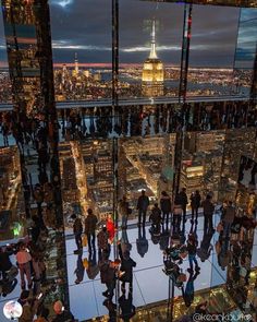 people are standing in front of the glass wall at the top of the empire building