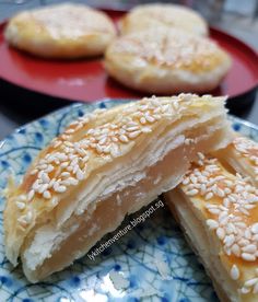 sesame seed pastries on a blue and white plate