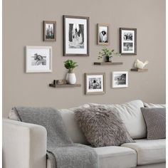 a living room filled with furniture and framed pictures on the wall above it's couch